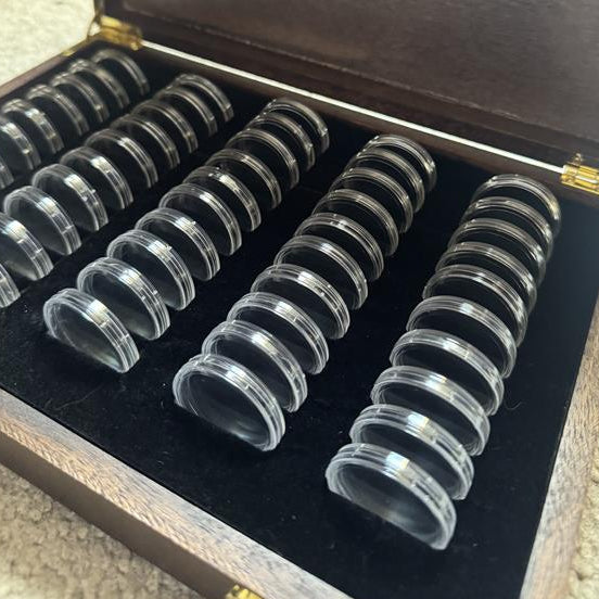 Set of coin holders in a wooden box with branding.