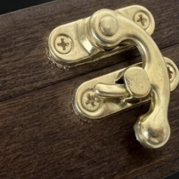Brass latch on a wooden surface