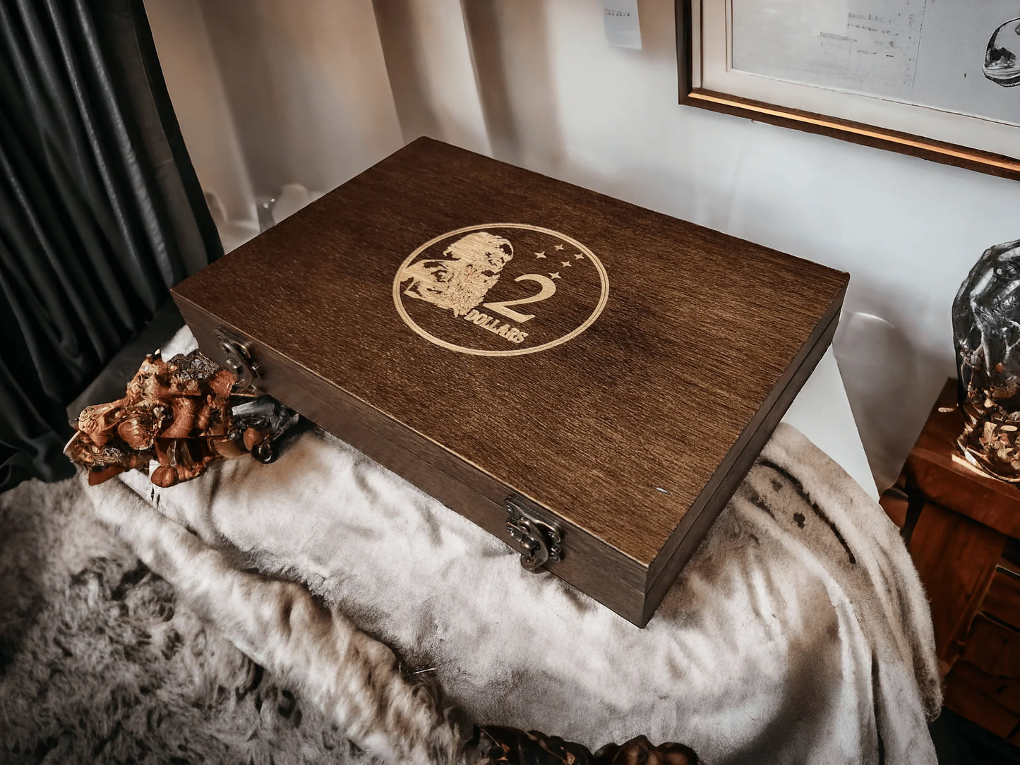 Handcrafted mahogany 2 dollar coin archive case featuring a laser-engraved Australian $2 coin logo, displayed on a textured throw in a luxury interior setting.